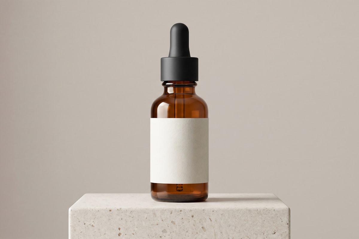 Amber glass dropper bottle of serum standing on a travertine stone block